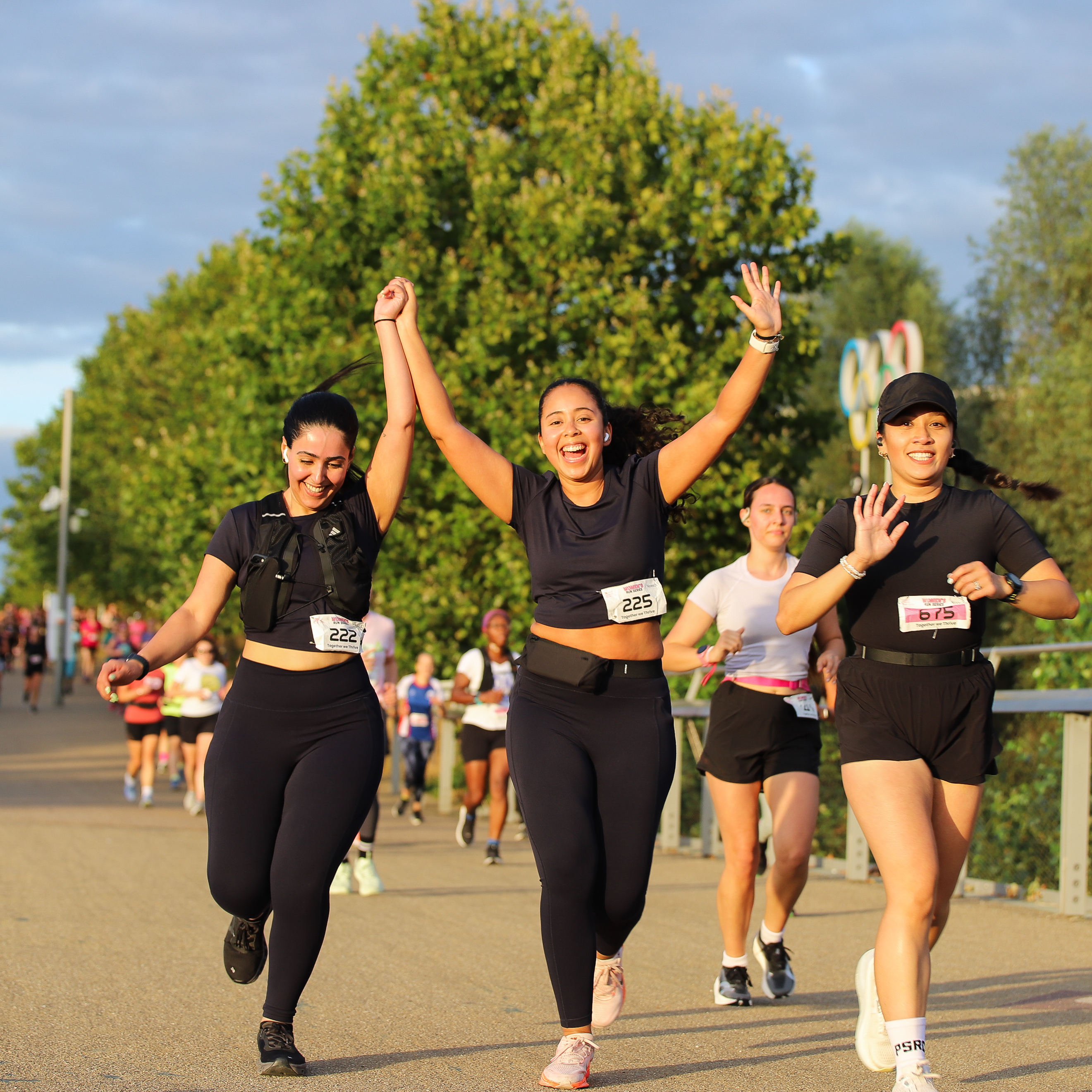 Women runners celebrating together during the Women’s Run Series, showcasing the supportive and inclusive atmosphere of the women-only running event.